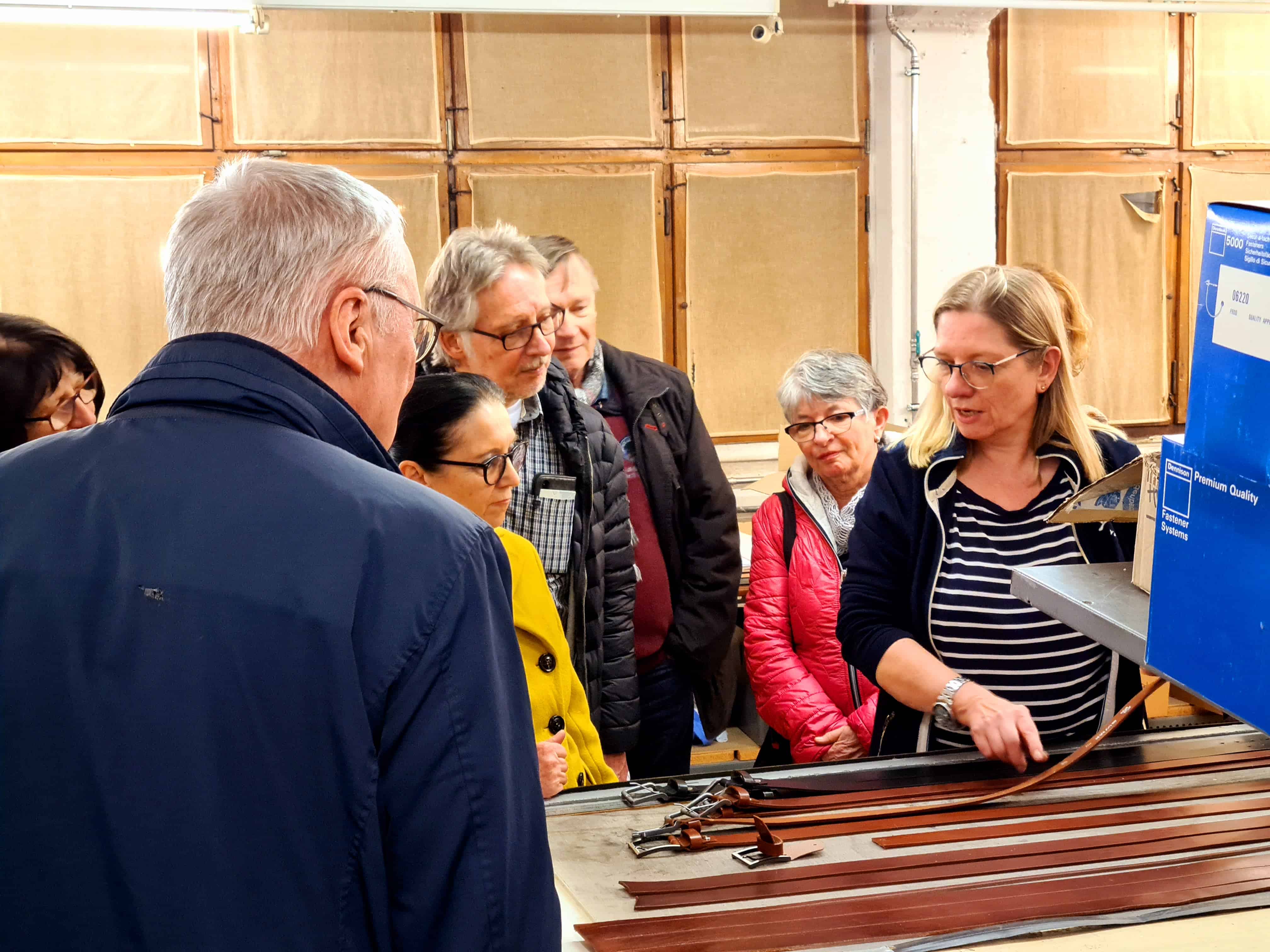 Touristen besuchen die Marbacher Manufaktur Hepco in einer Führung und lassen sich von einer Mitarbeiterin die Herstellung von Gürteln erklären