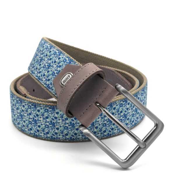 Ein elastischer Bandgürtel der Firma Hepco, mit altsilberner Schließe, brauner Lederpatte und einem kleinen floralen Muster in verschiedenen Blautönen.